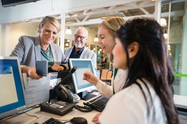 Affärskvinna innehav pass medan personalen jobba på flygplats — Stockfoto