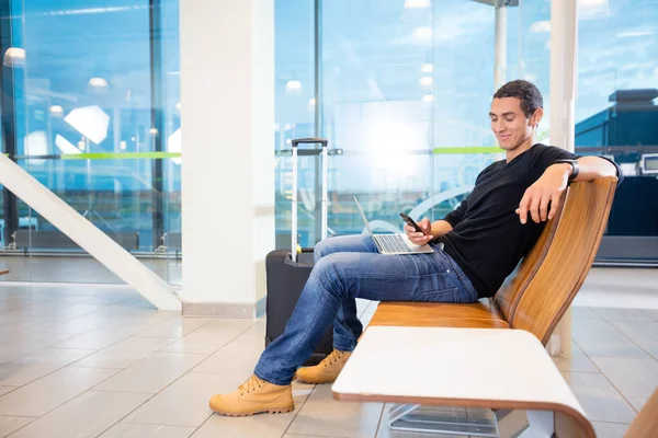 Cep telefonu ve Laptop Havaalanı'nda genç adam