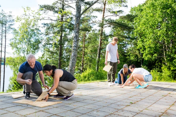 Multiethnic Friends Solving Wooden Plank Puzzle On Patio — Stock Photo, Image
