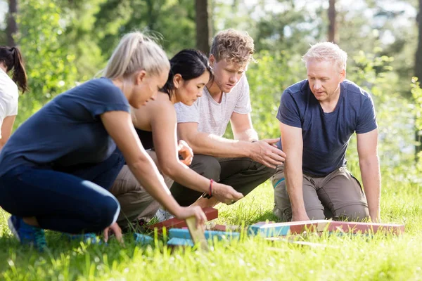 Vrienden van plan tijdens het spelen met bouwstenen op de met gras begroeide Fi — Stockfoto