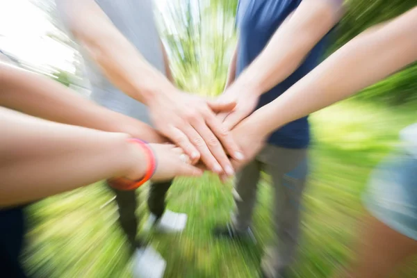 Closeup de colegas de trabalho empilhando as mãos na floresta — Fotografia de Stock