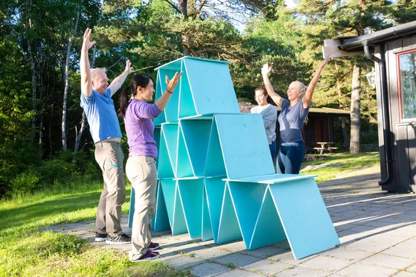 Freunde mit erhobenen Armen feiern Sieg nach Pyramidenbau — Stockfoto