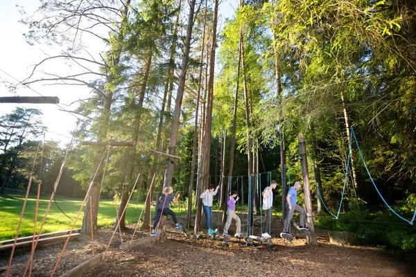 Colaboradores Multiétnicos Cruzando Registros de Balanço na Floresta — Fotografia de Stock