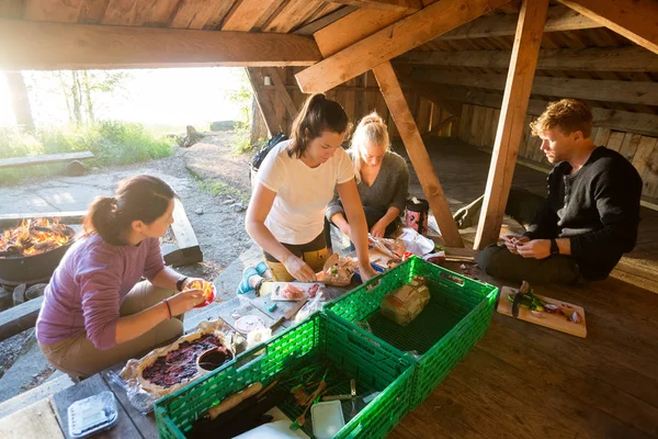 Συναδέλφους προετοιμασία των τροφίμων σε υπόστεγο στο δάσος — Φωτογραφία Αρχείου