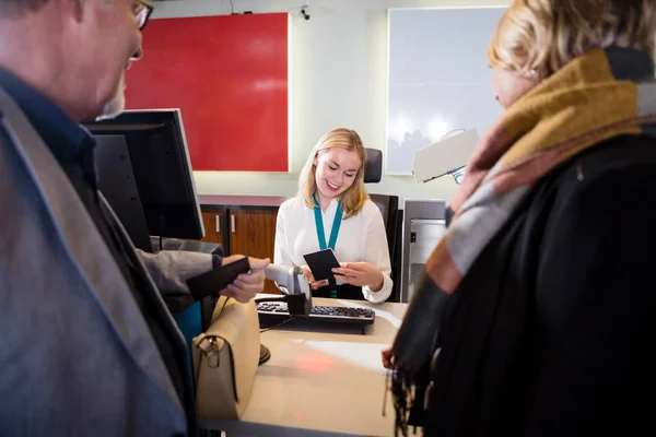 Personalen kontrollera pass av passagerare vid incheckning på flygplats — Stockfoto