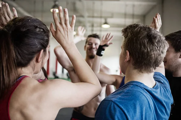 Pessoas dando cinco altos uns para os outros no ginásio — Fotografia de Stock