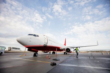 Bulutlu gökyüzü karşı ıslak pistte ticari uçak