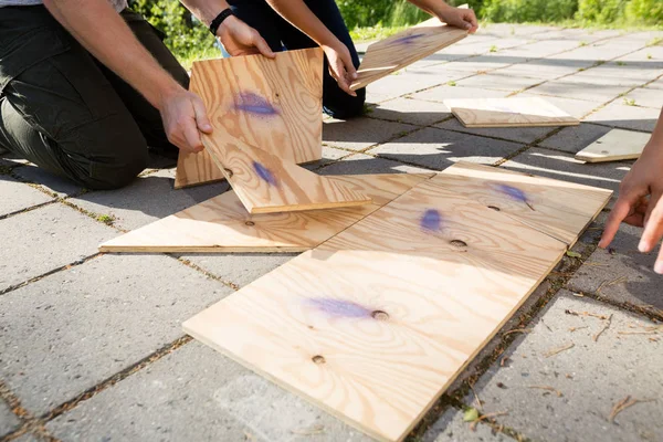 Imagem recortada de amigos organizando quebra-cabeça de madeira no pátio — Fotografia de Stock