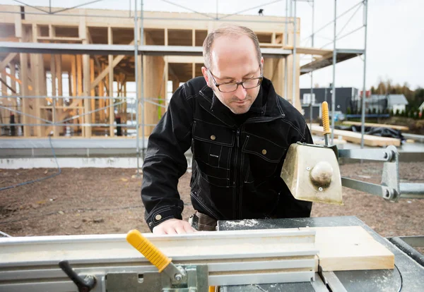 Carpenter Using Table Saw To Cut Plank At Site — Stock Photo, Image
