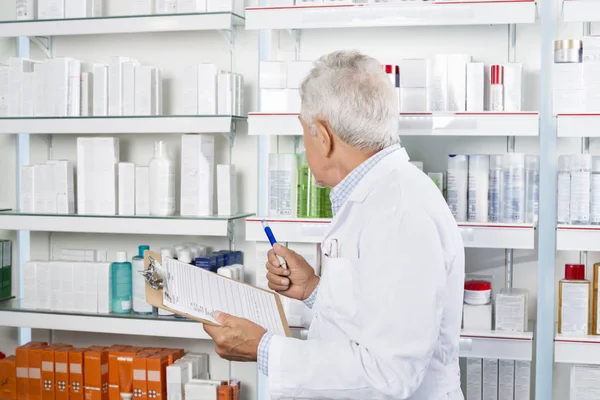Maschio farmacista che conta azione in farmacia — Foto Stock