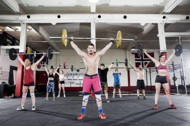 Eğitmen ile istemcileri barbell Fitness kulübünde kaldırma