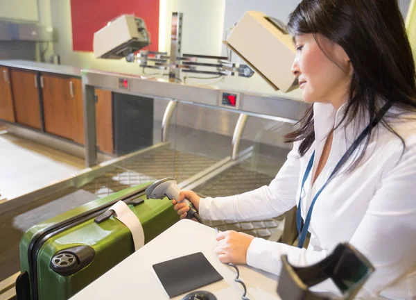 Etiqueta de escaneo de mujer en el equipaje en el check-in del aeropuerto —  Fotos de Stock