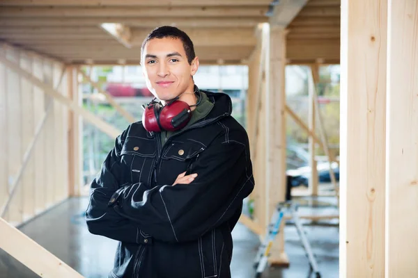 Timmerman glimlachen terwijl staande armen op Site gekruist — Stockfoto