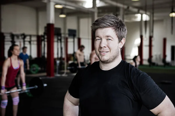 Selbstbewusster Mann lächelt im Fitnesscenter — Stockfoto