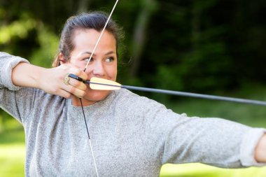 Kendine güvenen atlet orman içinde ok ve yayla hedefleyen