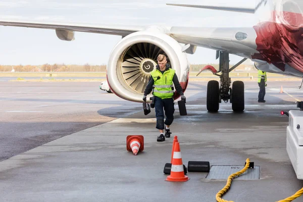 Arbetare som transporterar kilar av flygplan på våt bana — Stockfoto