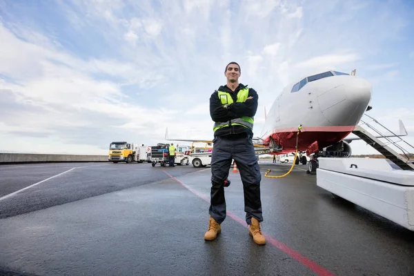 Selbstbewusster männlicher Arbeiter mit verschränkten Armen auf nasser Piste — Stockfoto