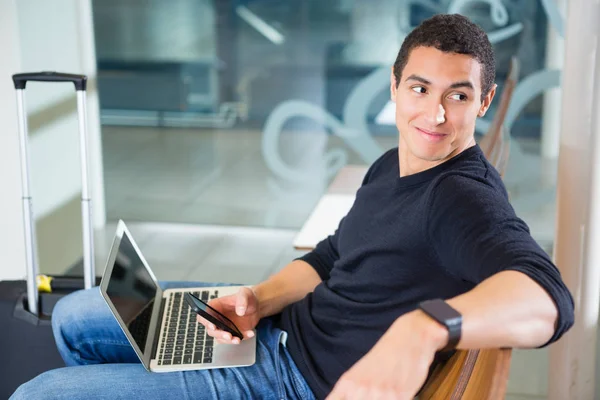 Joven con tecnologías en la zona de espera del aeropuerto — Foto de Stock