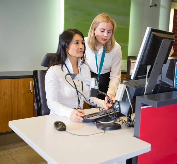 Kvinnlig personal som arbetar på flygplatsen vid incheckningsdisken — Stockfoto