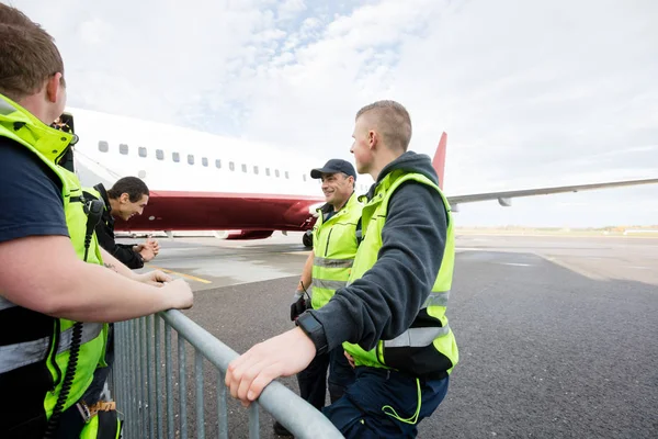 Bemanning communiceren door hek tegen vliegtuig — Stockfoto