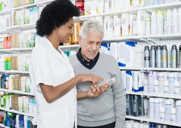 Farmacista Mostrando informazioni sul prodotto al cliente — Foto Stock