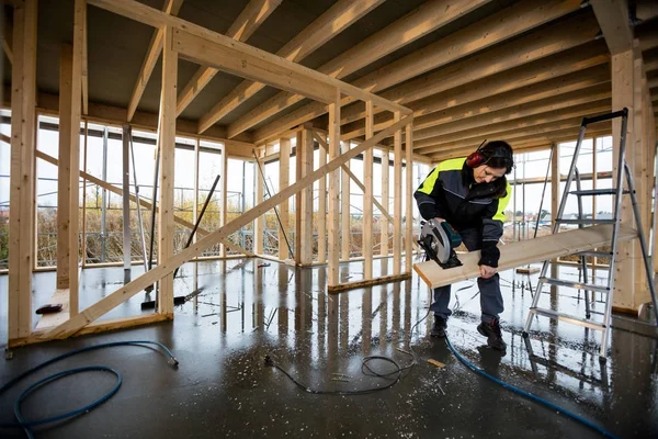 Elektrik kullanarak kadın marangoz kesme ahşap inşaat gördüm