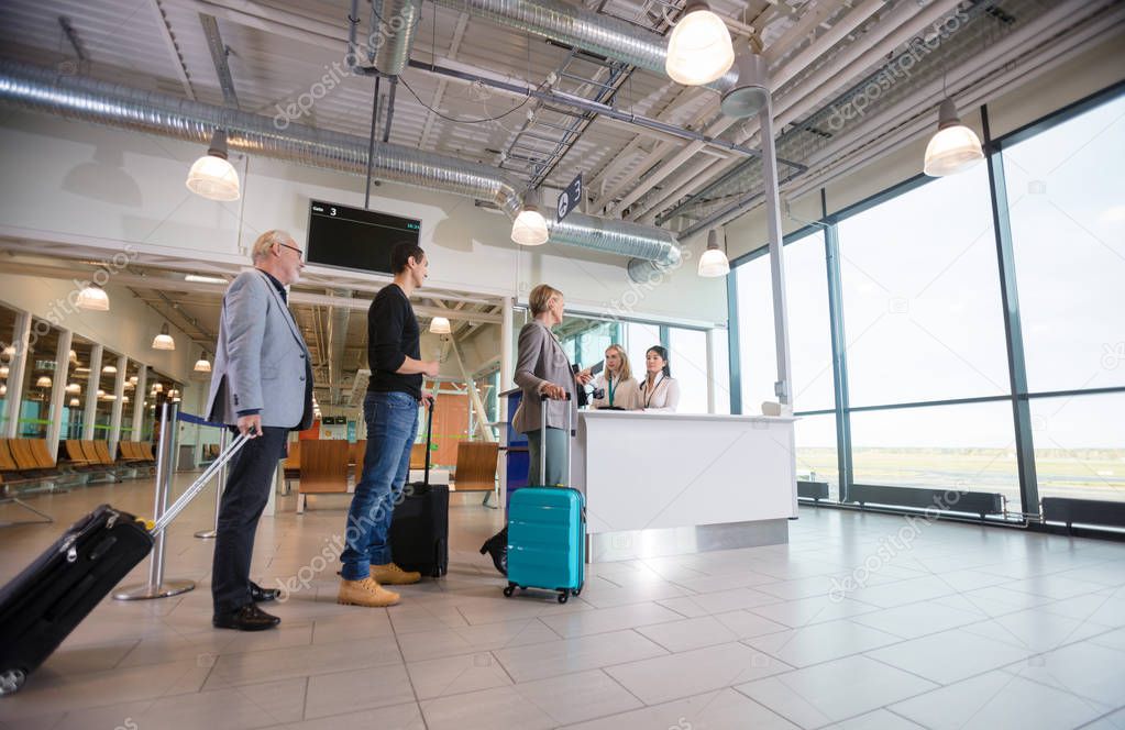 Passengers With Luggage Waiting At Reception In Airport