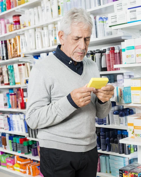 Senior kunden hålla låda i apotek — Stockfoto