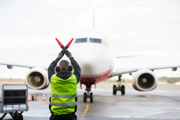 Marken arbetare signalering till flygplan på bana — Stockfoto