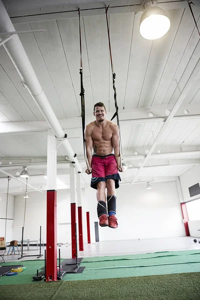 Ung Man med band motstånd i Gym — Stockfoto