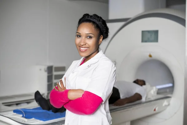 Médico con brazos cruzados mientras paciente en máquina de exploración CT —  Fotos de Stock