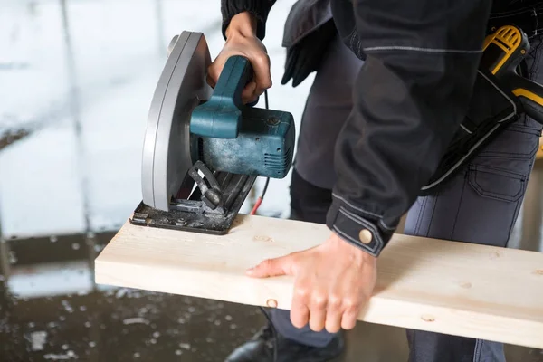 Section médiane du menuisier à l'aide d'une scie électrique pour couper le bois — Photo