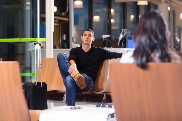 Uomo seduto sulla sedia in sala d'attesa in aeroporto — Foto Stock