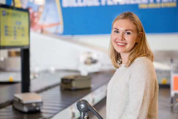 Schöne junge Frau lächelt am Flughafen — Stockfoto