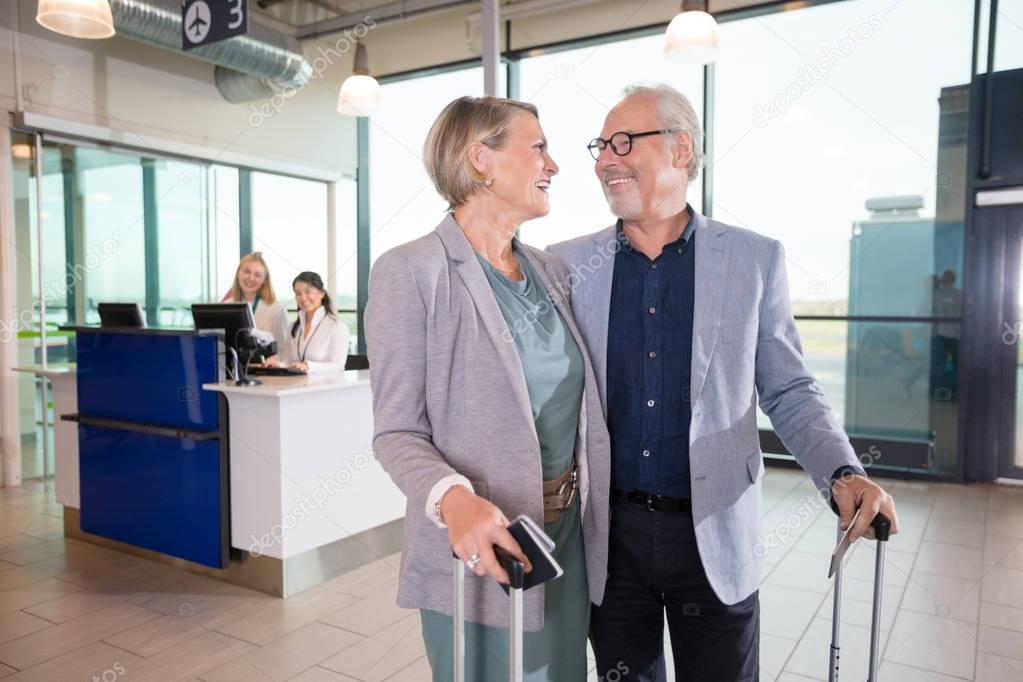 Happy Senior Business Couple Looking At Each Other In Airport