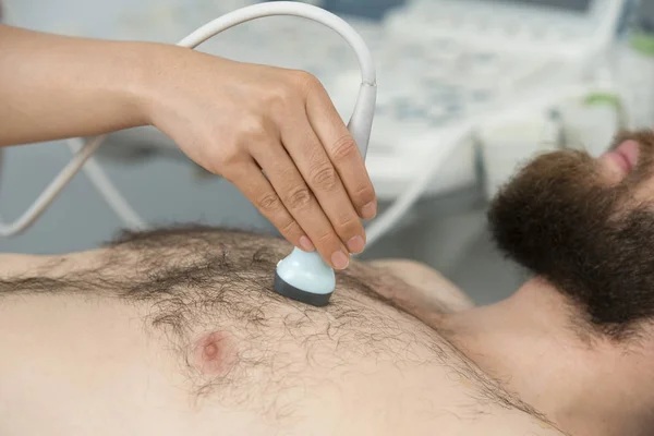 Dokter ultrasone sonde plaatsen op patiënten borst — Stockfoto