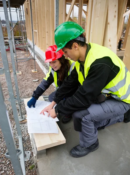 Carpinteros discutiendo sobre plan en el sitio de construcción —  Fotos de Stock