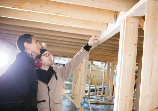 Carpenter Showing Wooden Beams To Colleague At Site — Stock Photo, Image
