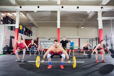 Eğitmen ile istemcileri barbell içinde jimnastik salonu kaldırma