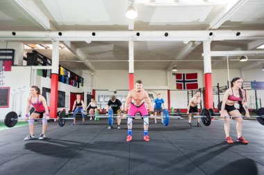 Barbell içinde jimnastik salonu kaldırma sporcu ile kararlı eğitmen