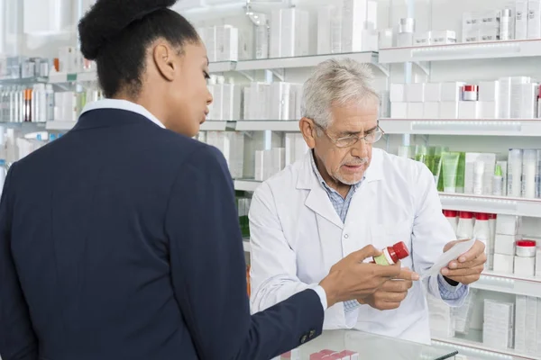 Kemist och affärskvinna med medicin och recept papper — Stockfoto