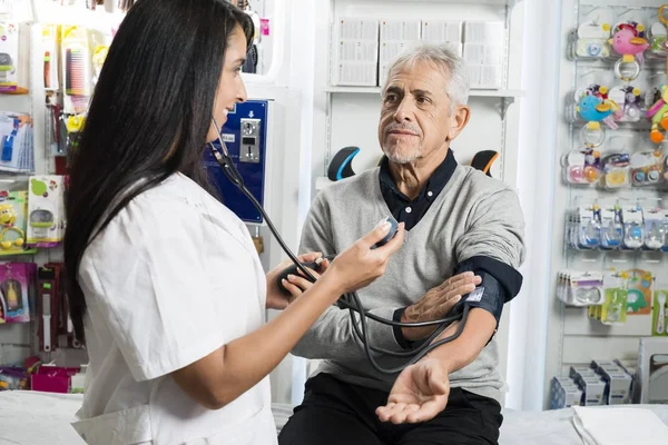 女性化学者の年配の男性の血圧をチェック — ストック写真