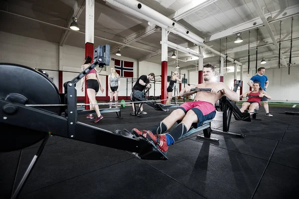 Man utövar på roddmaskin i gymmet — Stockfoto