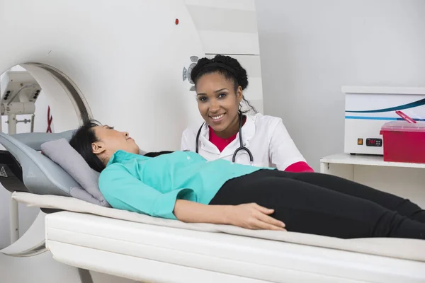 Médica sorridente por paciente em fase de tomografia computadorizada Fotos De Bancos De Imagens