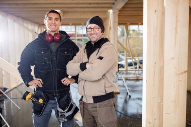İnşaat alanında ayakta kendine güvenen erkek marangozlar