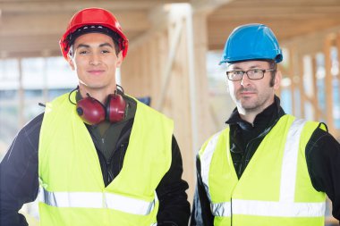Kendine güvenen marangozlar inşaat sahasında koruyucu giyim