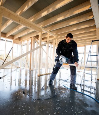 Elektrikli el kullanarak marangoz ahşap sitesinde kesmek için gördüm