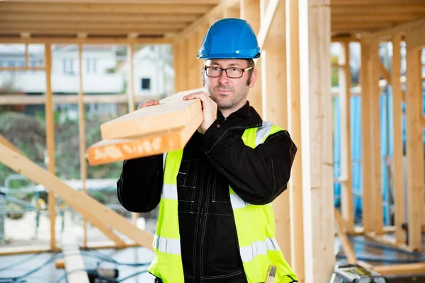 Carpenter Looking Away While Carrying Wood On Shoulder — Stock Photo, Image