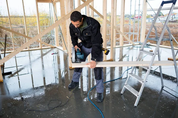 Carpenter Cutting Wood With Electric Hand Saw At Construction Si — Stock Photo, Image