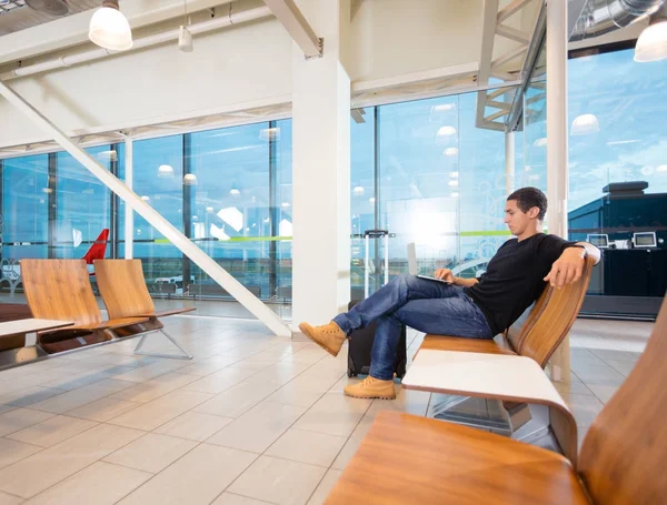 Ung Man använder Laptop flygplats lobbyn — Stockfoto